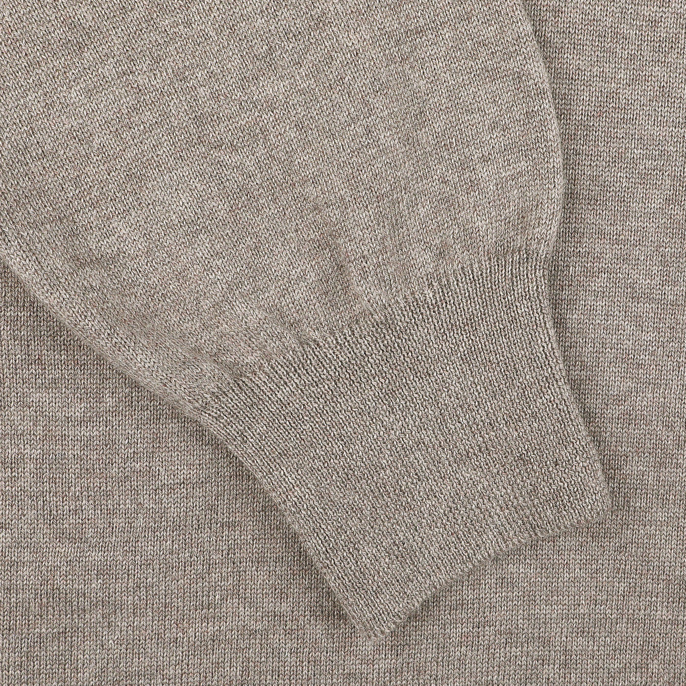 Close-up of a beige extra fine merino wool polo shirt sleeve with a ribbed cuff, crafted by Gran Sasso.