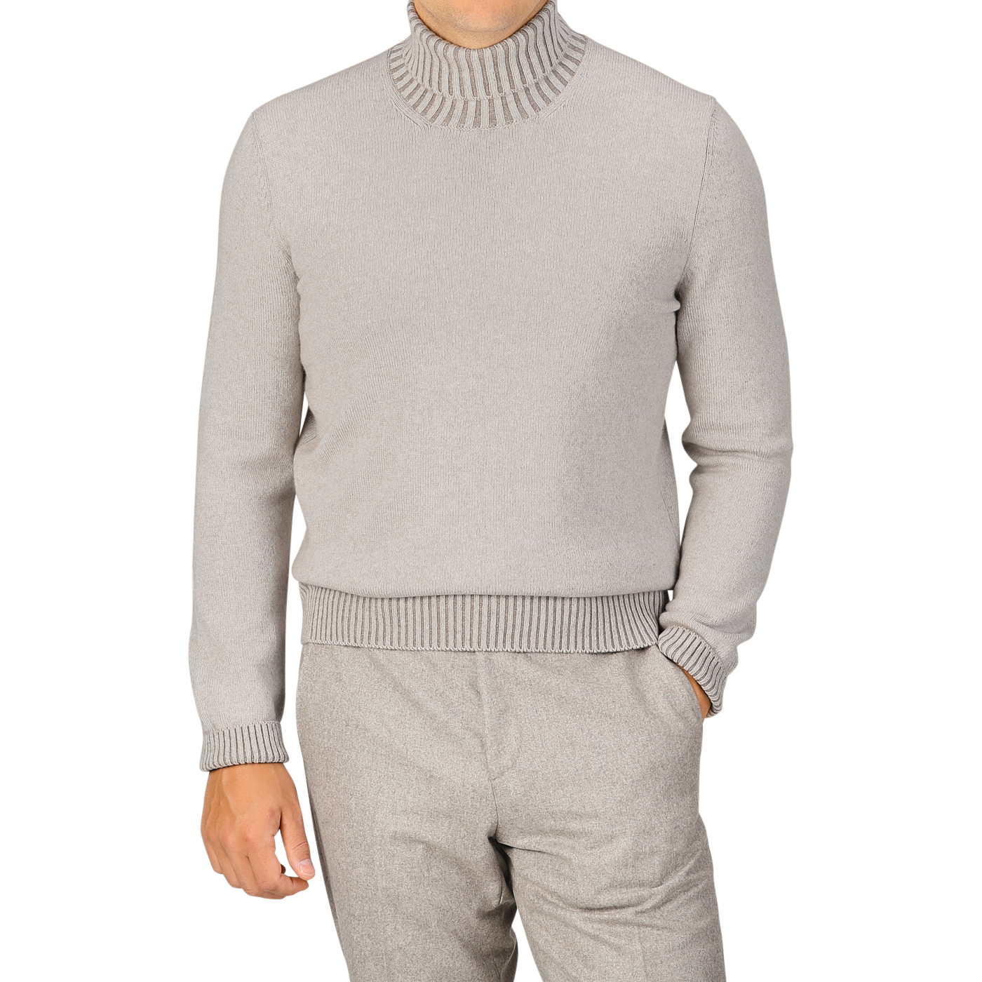 A person wearing a Beige Melange Pure Cashmere Rollneck sweater by Gran Sasso and matching light gray pants, with one hand in the pocket, standing against a plain background.