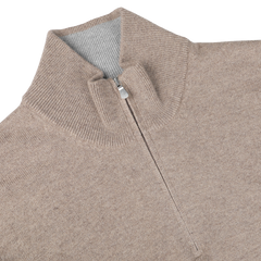 Close-up of the Beige Wool Cashmere 1/4 Zip Sweater by Gran Sasso, featuring a ribbed collar and a visible metal zipper pull. This durable and comfortable sweater is expertly crafted from sustainable knitwear.