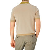 The back view of a man wearing a Gran Sasso Beige Cotton Contrast Collar Polo Shirt and khaki pants.