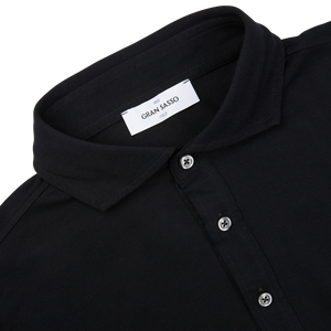 Close-up of a black cotton jersey popover shirt with a "Gran Sasso" brand label.
