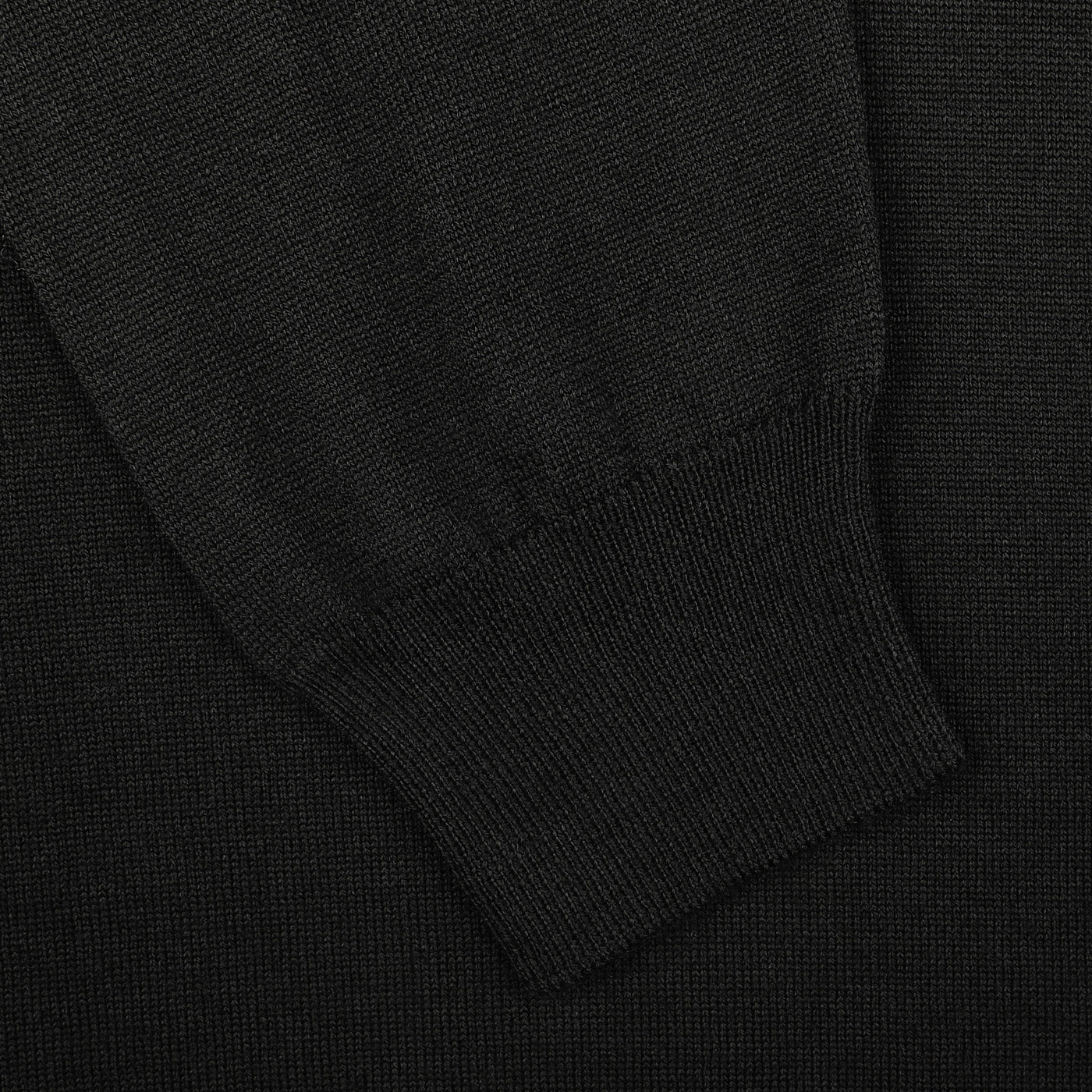 Close-up of a Gran Sasso Black Extra Fine Merino Crew Neck sweater sleeve featuring a ribbed cuff, crafted from luxurious merino wool.