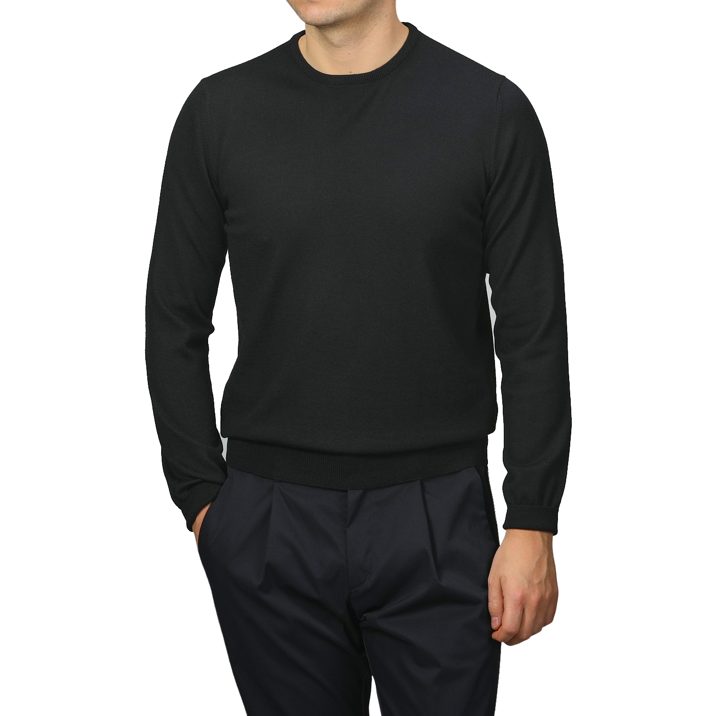 A person in Gran Sasso's Black Extra Fine Merino Crew Neck and dark pants stands against a gray background, displaying a sophisticated wardrobe choice.