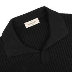 The Black Organic Cotton Polo Shirt from Gran Sasso is a ribbed chunky-knit piece featuring a folded collar and a "Gran Sasso" label inside the neckline.