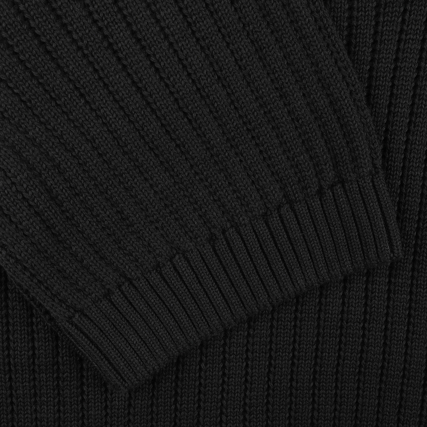 Close-up of a black ribbed knit fabric from the Black Organic Cotton Polo Shirt by Gran Sasso, highlighting overlapping sections common in slim fit designs.