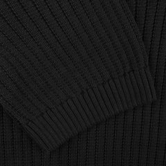 Close-up of a black ribbed knit fabric from the Black Organic Cotton Polo Shirt by Gran Sasso, highlighting overlapping sections common in slim fit designs.