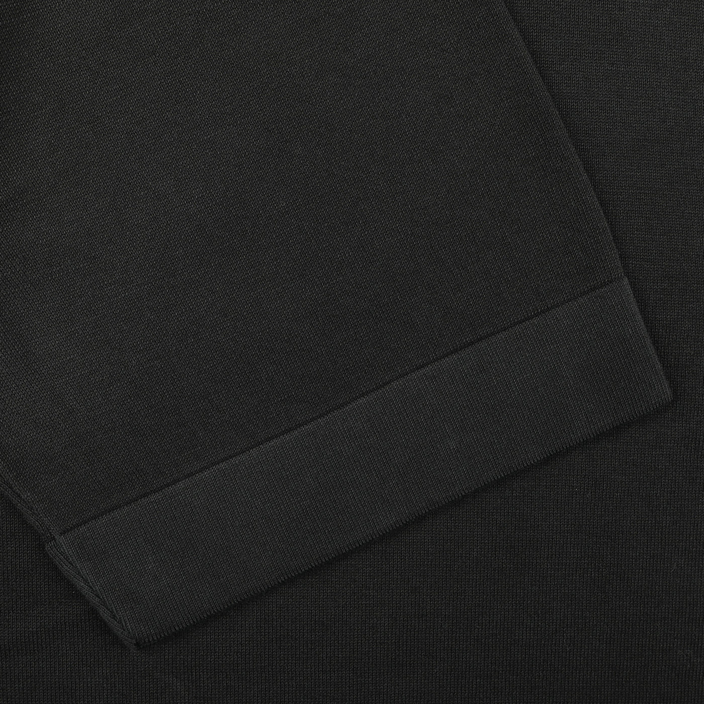 Close-up of a Gran Sasso Black Organic Cotton T-Shirt, displaying its soft, knit-like texture. The design features a folded cuff with visible stitching, enhancing its slim-fit appeal.