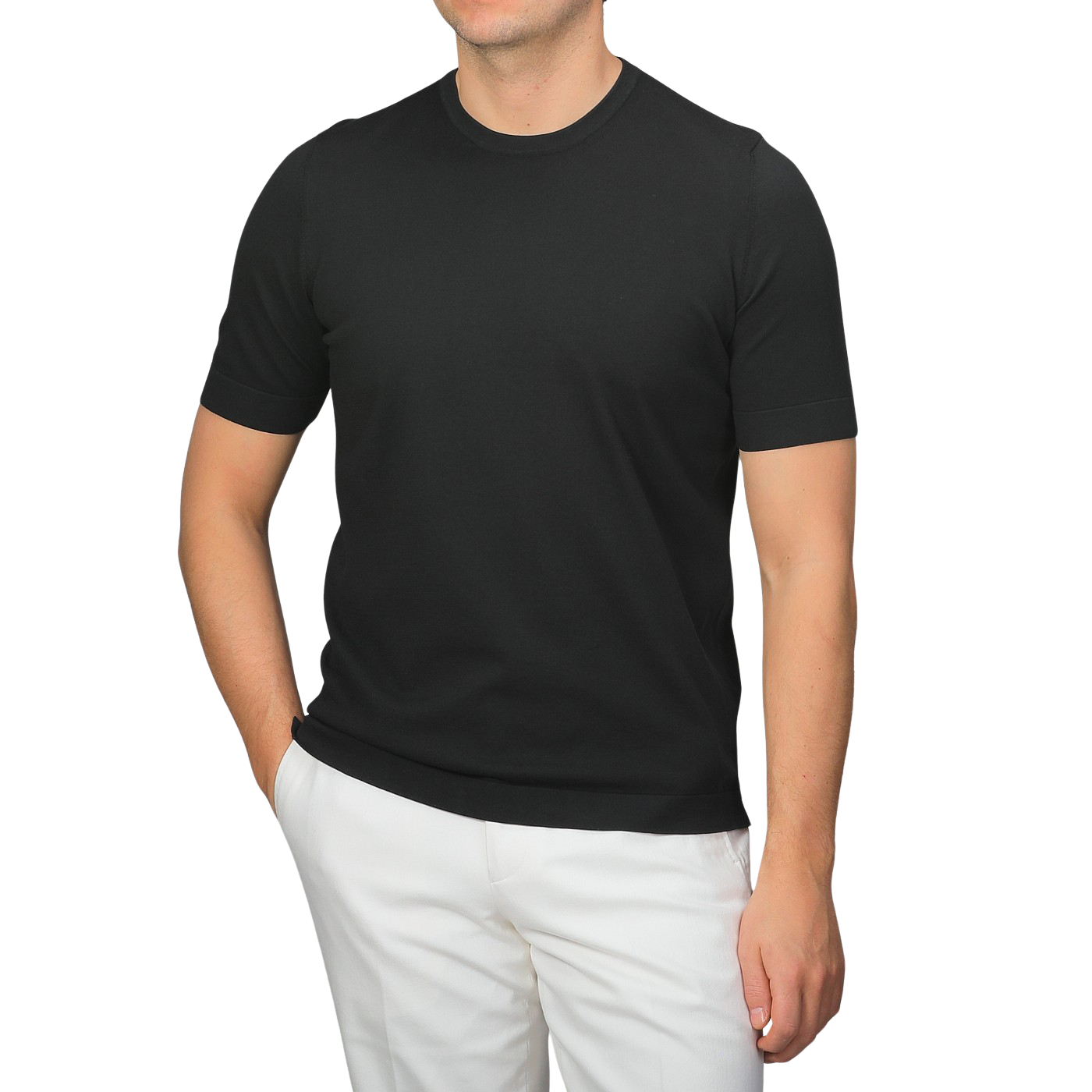 A man dressed in a slim-fit, Black Organic Cotton T-Shirt by Gran Sasso and white pants stands against a gray background.