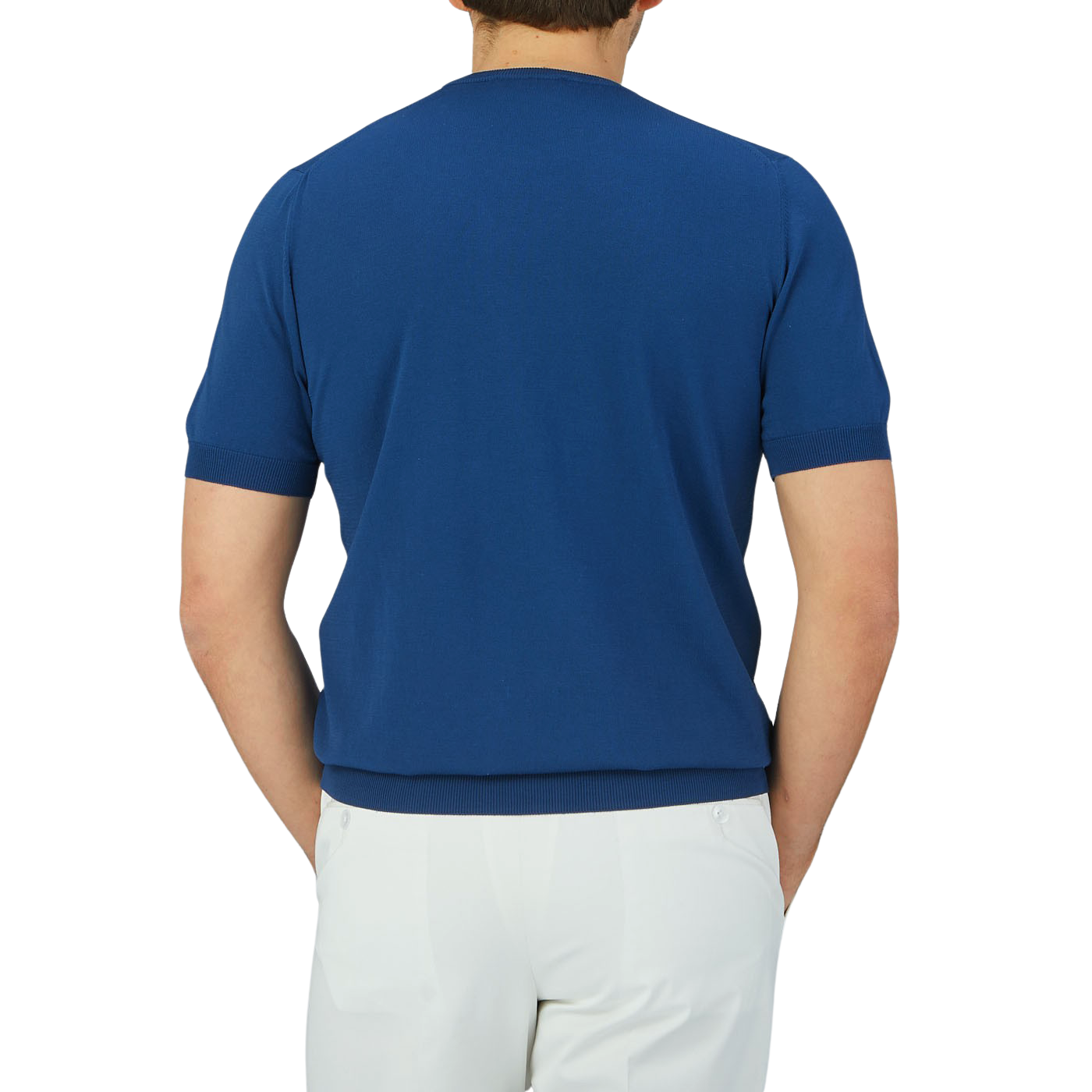 The back view of a man wearing a lightweight, Gran Sasso Indigo Blue Knitted Organic Cotton T-Shirt and white pants.
