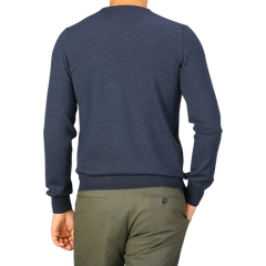 A person wearing a Blue Melange Extra Fine Merino Crew Neck by Gran Sasso and olive green pants, facing away from the camera.