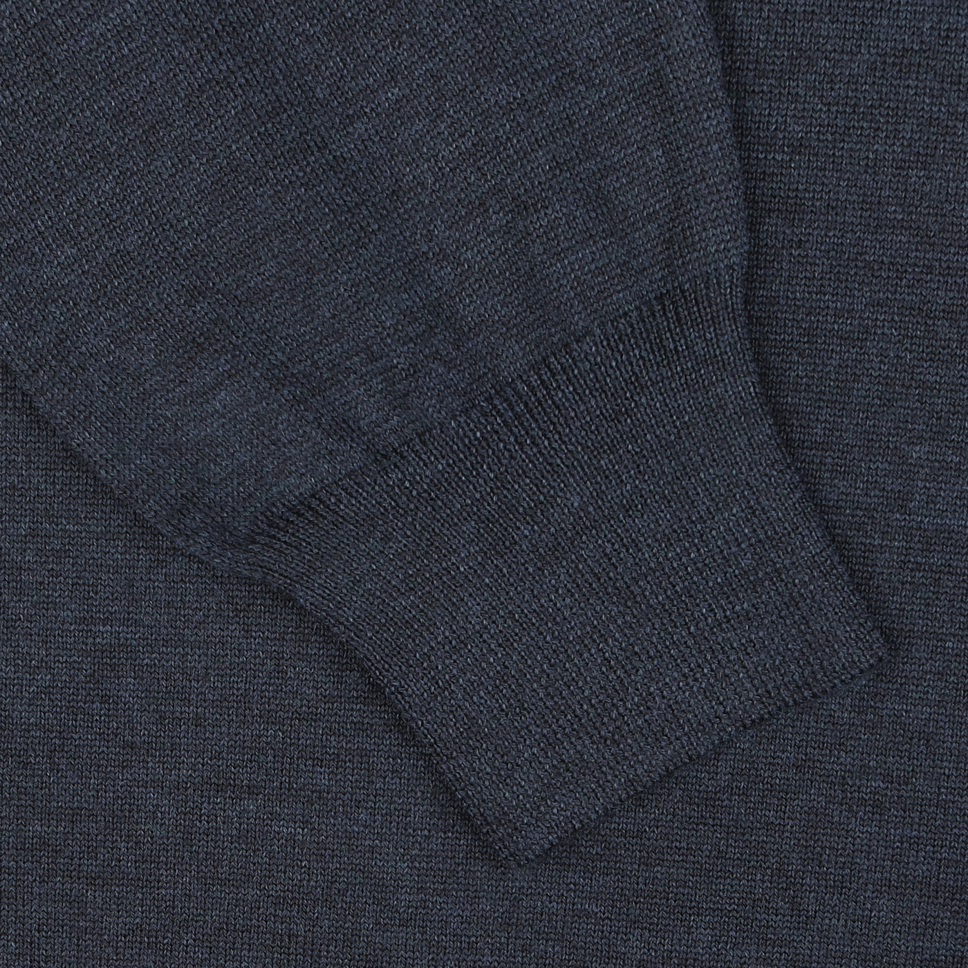 Close-up of a blue melange knitted fabric from Gran Sasso's Blue Melange Extra Fine Merino Crew Neck, showcasing a sleeve with a ribbed cuff that provides an extra layer of warmth.