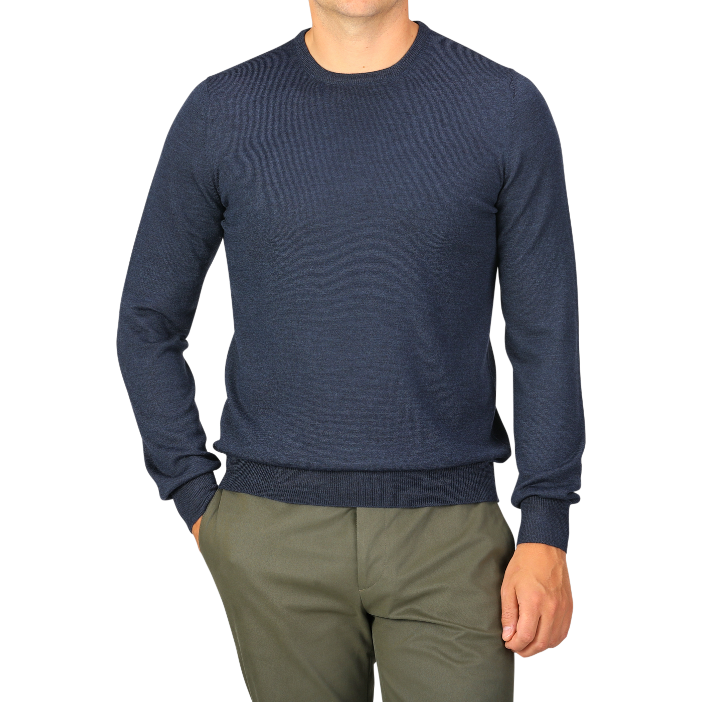 A person wearing a long-sleeve Blue Melange Extra Fine Merino Crew Neck by Gran Sasso with green pants stands with one hand in their pocket.