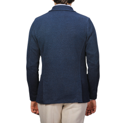 A person wearing a Gran Sasso Blue Melange Linen Cotton Knitted Blazer stands facing away, paired with beige pants against a plain gray background.