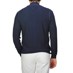 Wearing Gran Sasso's Blue Melange Vintage Wool Zip Cardigan, this person is seen from the back against a gray background while paired with white pants, exuding vintage vibes.