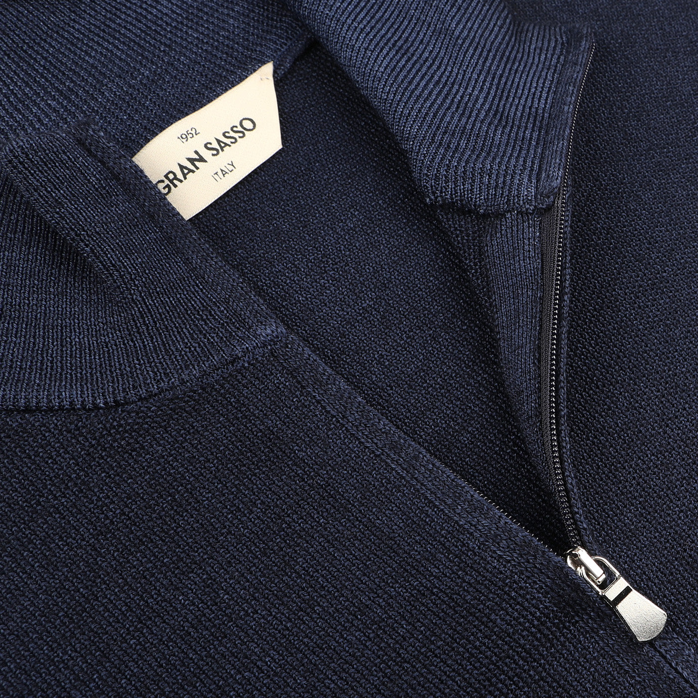 The Blue Melange Vintage Wool Zip Cardigan, crafted from pure virgin wool with a ribbed texture, features a "Gran Sasso" label inside the collar for added vintage appeal.