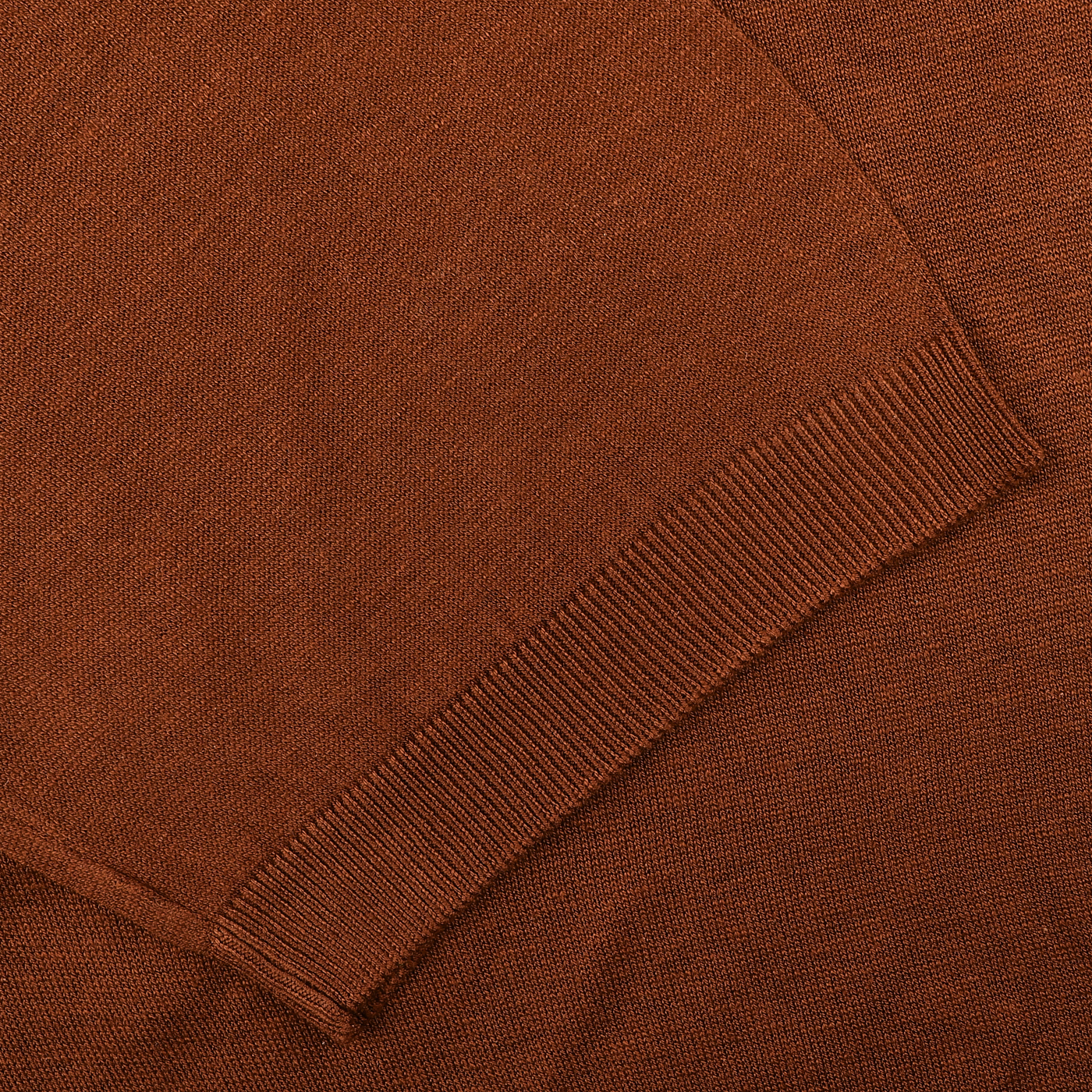 Close-up of a Brick Red Knitted Silk Polo Shirt by Gran Sasso, highlighting the ribbed texture of a seam and sleeve edge—an ideal summer wardrobe addition.