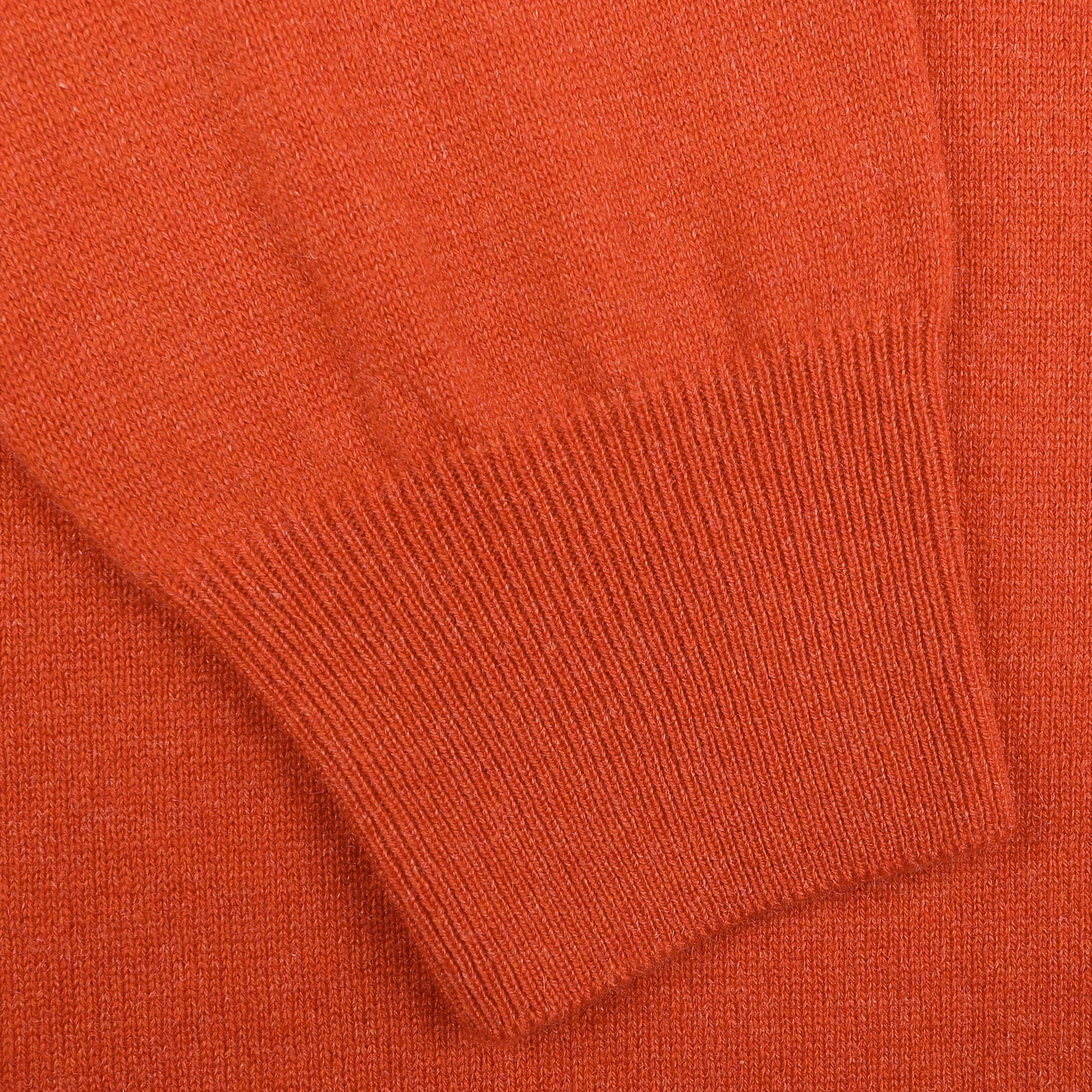 Close-up of the sleeve on the Bright Orange Cashmere 1/4 Zip Sweater by Gran Sasso, highlighting its ribbed cuffs and smooth fabric texture characteristic of their premium knitwear.