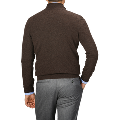 A person is standing with their back to the camera, wearing a Gran Sasso Brown Melange Cashmere 1/4 Zip Sweater and gray trousers.