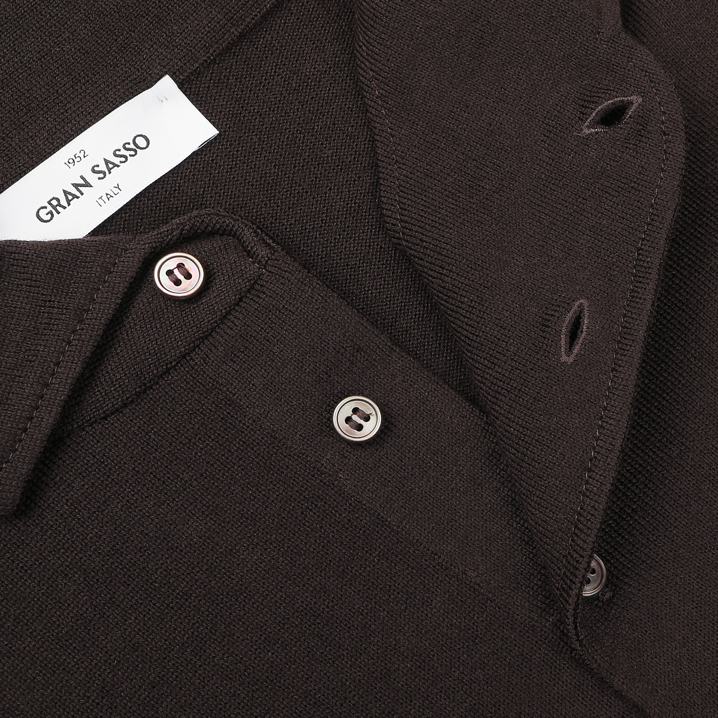 Close-up of a buttoned Brown Merino Wool One-Piece Collar Polo Shirt labeled "Gran Sasso," showcasing the button details and a partially visible brand tag, crafted from extra-fine merino wool.