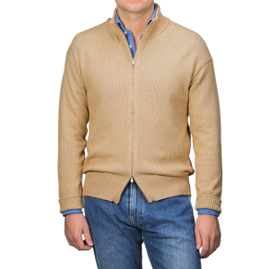 A man models the art of seasonal layering with a relaxed stance, showcasing the Gran Sasso Camel Beige Cotton Boucle Full Zip Cardigan over a blue shirt and jeans.