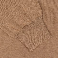 Close-up of a camel beige extra fine merino crew neck sweater sleeve with a ribbed cuff, crafted from luxurious virgin wool by Gran Sasso.