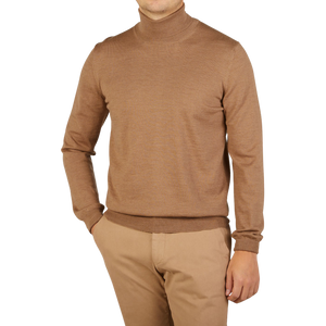 A man wearing a slim fit Gran Sasso Camel Beige Extra Fine Merino Roll Neck sweater and tan pants.