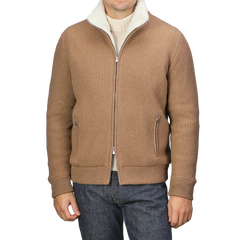 Dressed in a chic and refined knitwear ensemble, the individual is sporting Gran Sasso's Camel Beige Faux Fur Lined Cashmere Blouson over a cream turtleneck, complemented by dark jeans. The head remains out of view.