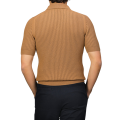 The person is wearing a Camel Brown Organic Cotton Polo Shirt by Gran Sasso, paired with dark slim-fit pants, viewed from the back.