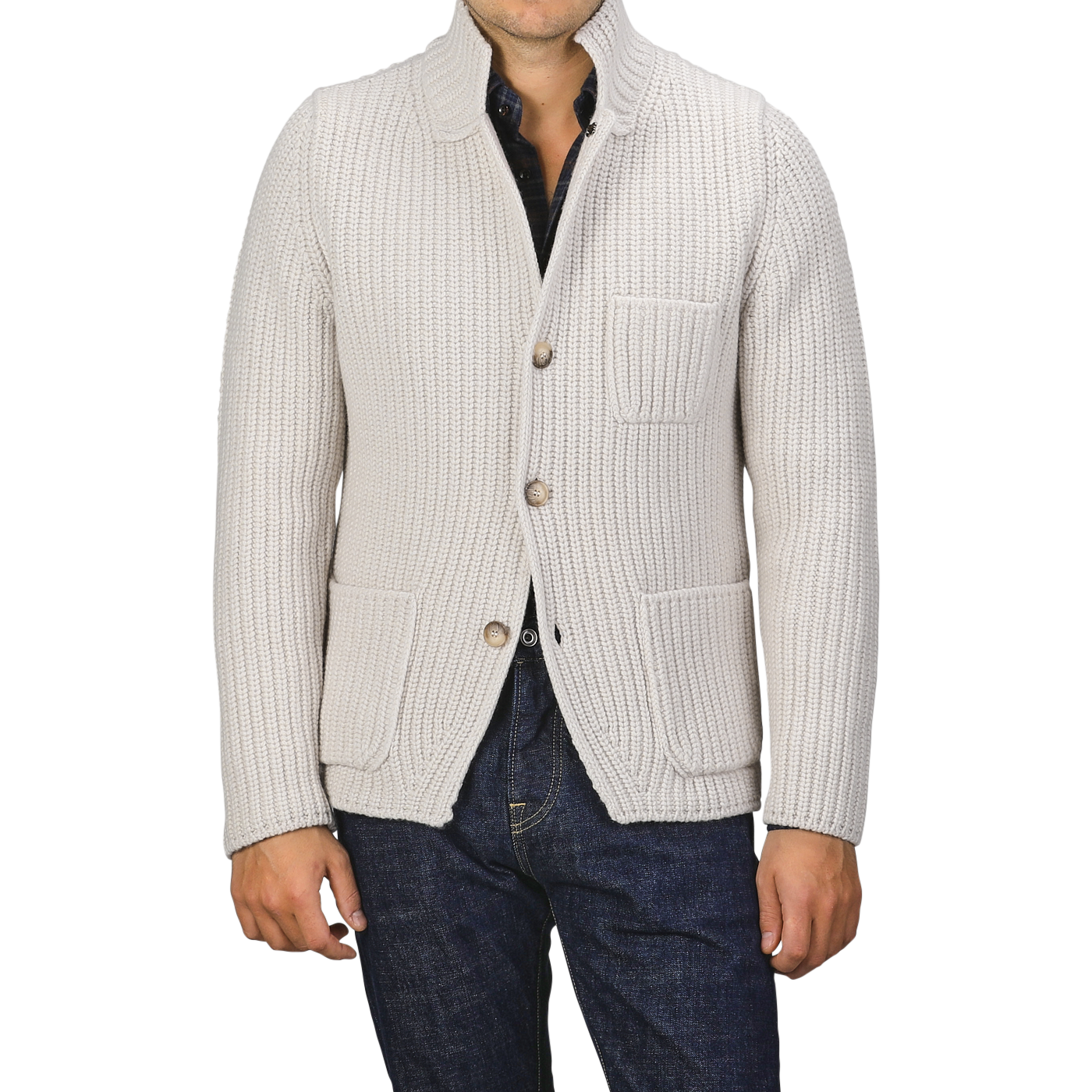 A man is wearing a Cream Beige Chunky Knitted Wool Cardigan by Gran Sasso, featuring a shawl collar and large front pockets, over a dark shirt and blue jeans. His face is not shown.