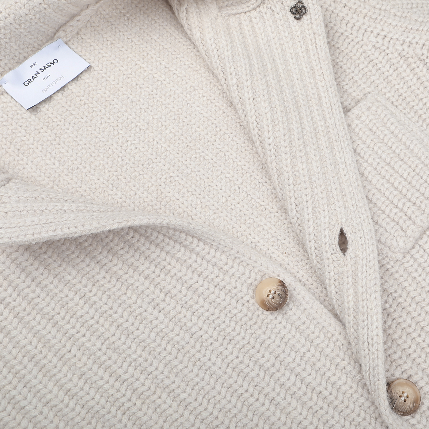 Close-up of the Cream Beige Chunky Knitted Wool Cardigan by Gran Sasso, showcasing its cream-colored wool knit, two beige buttons, a buttonhole, and the visible brand label.