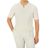 A man, dressed in a Cream Beige Cotton Linen Polo Shirt from Gran Sasso, completes his outfit with matching pants.