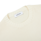 A close up of a Gran Sasso cream beige Egyptian cotton crewneck sweater with a label on it.