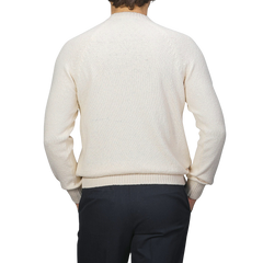 A person in a Gran Sasso Cream Cotton Boucle Crewneck Sweater and dark pants is facing away.