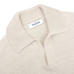 A slim-fit cream polo shirt, made from cotton-linen thread, lies flat with a label displaying "Gran Sasso Italy.