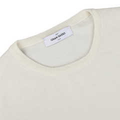 A close-up of the Gran Sasso Cream Extra Fine Merino Crew Neck sweater, known for its high-quality merino wool, featuring a round neckline and a visible brand label. This piece is perfect for any versatile wardrobe.