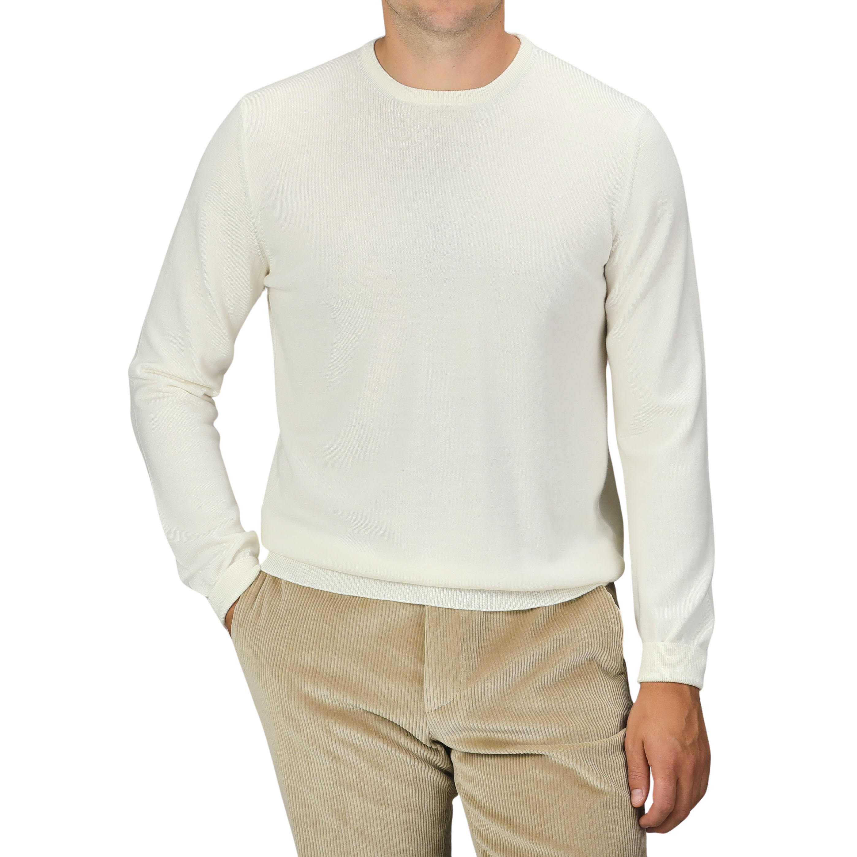 A person wearing the Cream Extra Fine Merino Crew Neck and beige corduroy pants from Gran Sasso, with their hand in their pocket, against a black background.