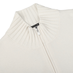 Close-up of the Cream Felted Cashmere Zip Cardigan by Gran Sasso, featuring a high, ribbed collar. The zipper is partially unzipped, revealing a black tag. This contemporary fit includes felted cashmere for added warmth and luxury.