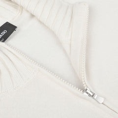 Close-up of a Gran Sasso Cream Felted Cashmere Zip Cardigan with a partially unzipped zipper, revealing the ribbed texture of the fabric near the collar. A black label with white text is attached to the inner seam, highlighting its contemporary fit.