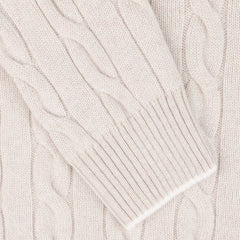 Close-up of a Gran Sasso Cream Pure Cashmere Quarter Button Sweater sleeve, showing intricate woven patterns and ribbed cuff.