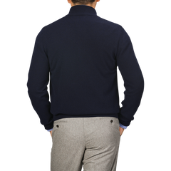 A person wearing a Gran Sasso Dark Blue Wool Cashmere 1/4 Zip Sweater and light gray pants is shown from the back, standing with their hands in their pockets.