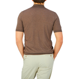 The back view of a man wearing a Gran Sasso Dark Brown Knitted Silk Polo Shirt for a cooling effect.