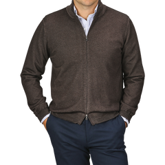 A person wearing a Gran Sasso Dark Brown Vintage Merino Zip Cardigan, a white and blue striped shirt, and dark blue pants, with their hands in their pockets. The background is transparent.