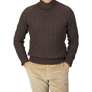 A person is wearing a Gran Sasso Dark Brown Wool Cable Knit Rollneck sweater made from pure virgin wool and beige corduroy pants, with hands in pockets.