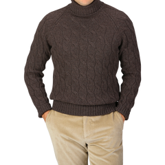 A person is wearing a Gran Sasso Dark Brown Wool Cable Knit Rollneck sweater made from pure virgin wool and beige corduroy pants, with hands in pockets.