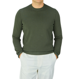 A man wearing a Gran Sasso Dark Green Egyptian Cotton Crewneck Sweater, paired with white pants.