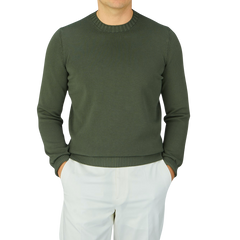 A man wearing a Gran Sasso Dark Green Egyptian Cotton Crewneck Sweater, paired with white pants.