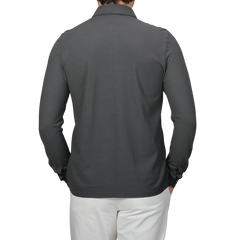 A person is facing away, wearing Gran Sasso's Dark Grey Washed Cotton Popover Shirt and white pants. The pure cotton jersey fabric pairs well with the sleek, slim fit of the outfit.