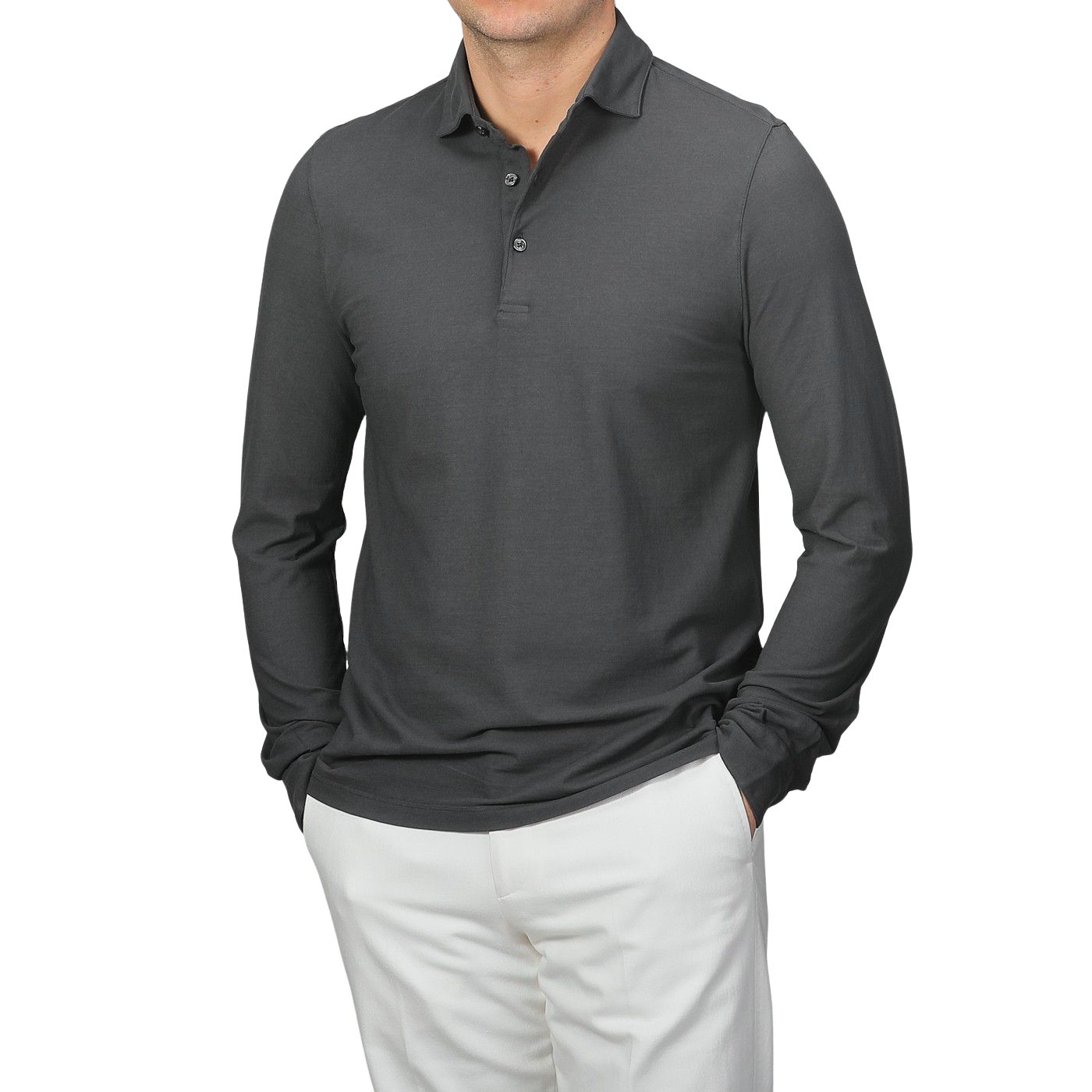 Wearing a Gran Sasso Dark Grey Washed Cotton Popover Shirt with white pants, an individual stands against a neutral background. The slim fit of the pure cotton jersey accentuates their silhouette as they casually rest their hands in their pockets.