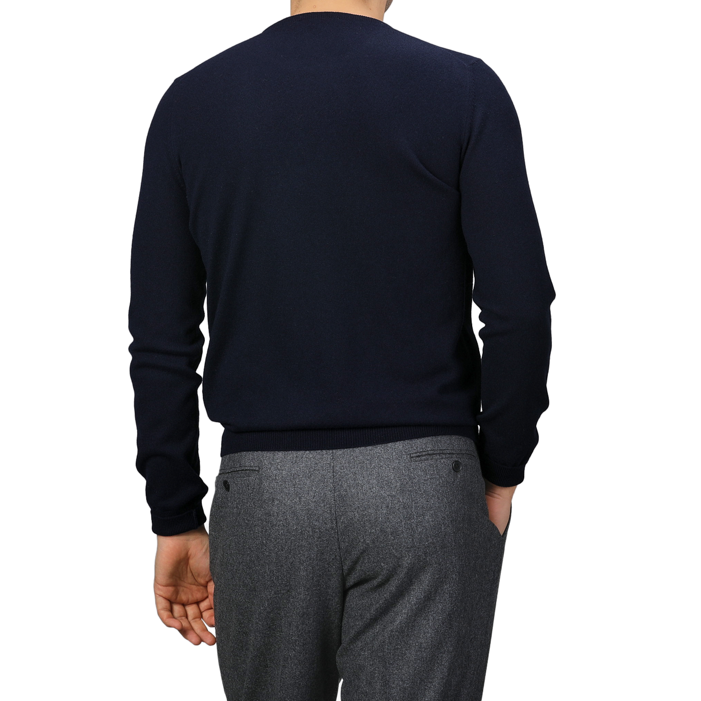 A person wears a Dark Navy Cashmere Crewneck Sweater by Gran Sasso, paired with gray pants, and is shown from the back.