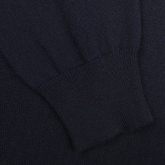 Close-up of a dark knitted fabric, featuring the ribbed cuff of the Dark Navy Cashmere Crewneck Sweater by Gran Sasso. The texture is smooth with visible stitching, highlighting the elegance of pure cashmere in sustainable knitwear.